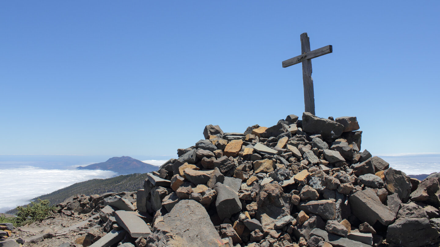 hinter dem Gipfelkreuz des Pico de la Nieve erhebt sich die Cumbre Vieja aus den Wolken