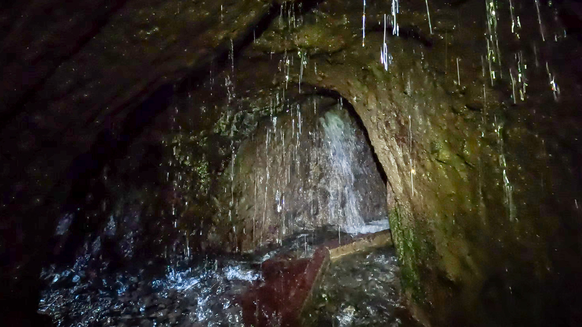 Wasser strömt im letzten Tunnel vor den Marcos Quellen aus den Felswänden